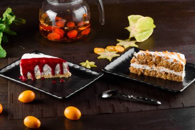 Çilek soslu cheesecake ve ekşi kremalı havuçlu kek ve siyah kare tabakta karamel.
