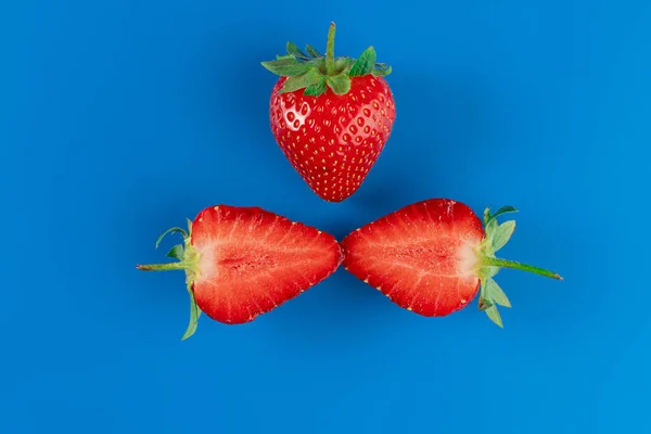 Erdbeerscheiben Großaufnahme Und Ein Ganzes Stück Erdbeeren Auf Blauem Hintergrund — Stockfoto