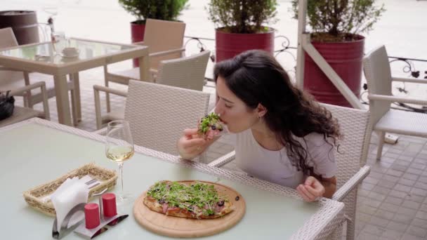 Chica comiendo pinsa romana en la cafetería en la terraza de verano. Scrocchiarella. Cocina gourmet italiana. — Vídeos de Stock