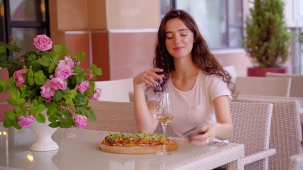Chica con pinsa romana relajarse y hablar por teléfono en la cafetería en la terraza de verano. Scrocchiarella. Cocina gourmet italiana. — Vídeos de Stock