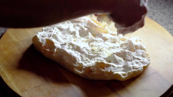 Процесс приготовления Pinsa romana с осьминогом. Шеф добавляет сыр в тесто с соусом. Скроккьярелла. Итальянская кухня для гурманов. — стоковое видео
