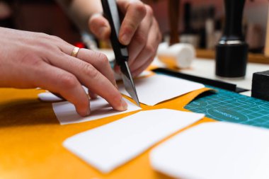 Keskin bıçak ve şablonlarla deri işçiliği. Bıçak ve şablonla deri kesimi. Esnaf kaliteli deriyi keskin bıçak ve kağıt şablonlarla keser.