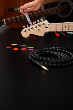 Gitar telleri cilalanmış bir başlık üzerinde temiz bir plastik Winder ile sıkılaştırılır. Gitar Bakım ve İp Değiştirme. Gitar başlığı bir iple ayarlanıyor.