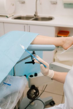 Jinekolog rahim kanseri ve diğer anormallikleri erken teşhis etmek için steril fırçayla Pap smear örneği topluyor. Steril sitoloji fırçası bir Pap smear testi sırasında kullanılır