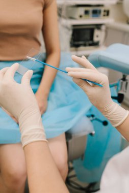 Servikal hücreler incelenmek üzere mikroskoba uygulanır. Test için bir slaytta Pap smear örneği. Jinekolog steril fırça kullanarak sitoloji slaytı hazırlıyor.