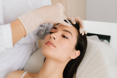 Alnına yakın çekim. Alnındaki botulinyum toksin enjeksiyonu ince çizgileri yumuşatıyor ve kasları gevşetiyor. Botulinum toksinli cerrahi olmayan alın gençleştirme