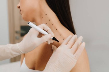 Nefertiti kaldırmadan önce işaretle. Kozmetik uzmanı bir kadının platizmasına botulinyum toksin enjekte edilmeden önce nokta çiziyor. Bir profesyonelden boyun geliştirme. Kadın estetik kozmetolojisi