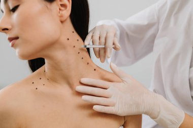 Kozmetik uzmanı kızın platizmasına botulinyum toksin enjekte etmeden önce nokta çiziyor. Nefertiti boyunda işaretli noktalarla enjeksiyonu kaldırıyor.