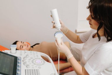 Ultrason cihazına jel sürmek daha iyi ses iletimi için hava boşluklarını ortadan kaldırır. Ultrason jel uygulaması. Etkili ses dalgası iletimi için dönüştürücüye ultrason jeli uygulanır