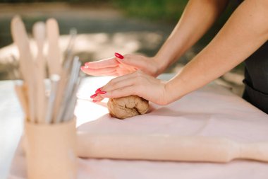 Çömlekçilikte kil hazırlığı. Çamur kalıpları dikkatli yoğurmayla başlar, sanatçılara heykel yapma konusunda esneklik ve güç verir. Clay havayı temizlemek ve dokuyu geliştirmek için yoğurulur.