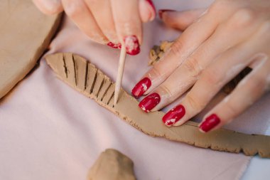 Kil sanatının yakından bakınca dekoratif oyma teknikleri görülüyor. Clay Dekorasyon ve Detaylar. Çömlekçiler el yapımı seramiklere kesin çizgiler çizerken Clay dekorasyonu sanatsal ayrıntıları vurguluyor