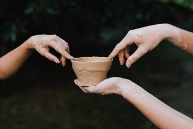 El yapımı kil kase direksiyondan çıkarıldıktan sonra tutulur. Seramik demlik sanatsallığı, sabrı ve kültürel geleneği yansıtır. Ellerindeki kil çömlek bitti.