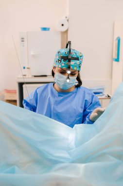 Steril aletler kullanarak minimal invaziv jinekolojik prosedür. Steril jinekoloji kliniğinde devam eden jinekolojik prosedür. Jinekolog rahim içi müdahalede bulunuyor.