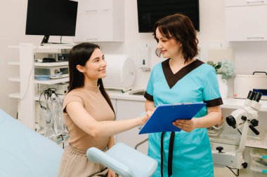 Jinekolog jinekoloji muayenesi sırasında koloskopi aletleri kullanıyor. Koloskopi ekipmanlarıyla jinekolog muayenesi. Jinekolog leğen kemiği incelemesi için koloskopi ekipmanlarını hazırlıyor.