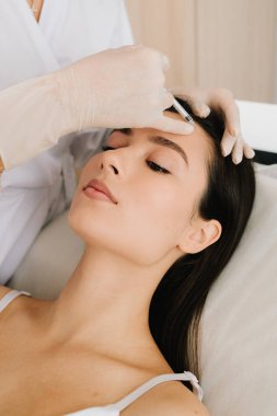 Alnına yakın çekim. Alnındaki botulinyum toksin enjeksiyonu ince çizgileri yumuşatıyor ve kasları gevşetiyor. Botulinum toksinli cerrahi olmayan alın gençleştirme