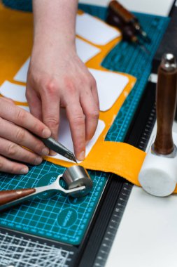 Bıçak ve şablonla deri kesimi. Esnaf kaliteli deriyi keskin bıçak ve kağıt şablonlarla keser. Hassas bıçak ve şablonlarla deri işçiliği