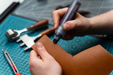 Boyama işaretiyle bitiş çizgisinde. Esnaf deri parçasına kenar boyası sürerek dayanıklılığını arttırıyor. Zanaatkar koyu kenarı deri kesimine uygular. Güç, pürüzsüzlük ve incelik ekler.