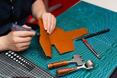 Boyama işaretiyle bitiş çizgisinde. Esnaf deri parçasına kenar boyası sürerek dayanıklılığını arttırıyor. Zanaatkar koyu kenarı deri kesimine uygular. Güç, pürüzsüzlük ve incelik ekler.