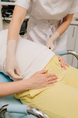 Jinekolog, doğum öncesi muayenede anne göbeği büyüklüğünü ölçerek bebeğin büyümesini takip ediyor. Hamilelik kontrolü. Jinekolog, bebeğin gelişimi ve gelişimi için anne karnını ölçüyor.