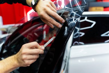 Detaylı olarak yan cama siyah film montajı ve rafine edilmesi. Koyu renk için kenar bitirme fazla filmi kaldırır ve pürüzsüz yapışmayı sağlar. Yan pencere filmi yakın plan şekillendirmesi