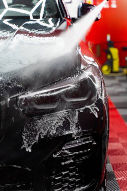 Araba gövdesinden kir ve köpük çıkarmak için yüksek basınçlı su jeti. Yüksek basınçlı su ile araba temizleme işlemi vücut panellerinden kiri ve köpüğü boyayı ve camları lekesiz bırakıyor.