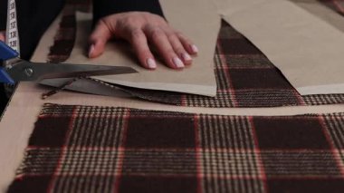 Kumaşı kesmek için makas kullanarak 4k video. Kumaşı makasla kesmek dikiş için kağıt desenler, DIY giysiler ve tekstil el sanatları kullanmak..