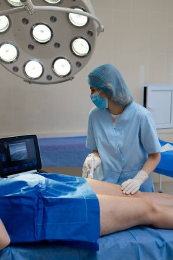 Hasta bacak damarları doktor tarafından ultrasonla kontrol edildi.