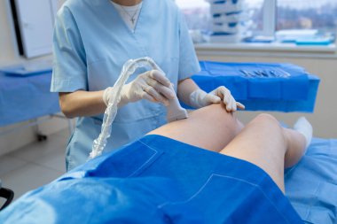 Doktor bacak damarlarında ultrason yapıyor.