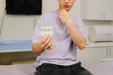 Erkek, idrar yolu enfeksiyonu, sistit veya böbrek enfeksiyonu için ilaç tutuyor.