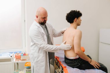 Böbrek hassasiyetini kontrol etmek için ürolog böbrek muayenesi yapıyor.