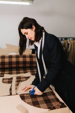 Tasarımcı kumaşı makas ile elle keser, kıyafet ve giysi için takip eden düzenler