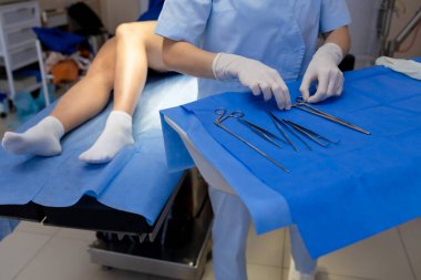 Damar uzmanı bacak damar ameliyatı için aletler hazırlıyor