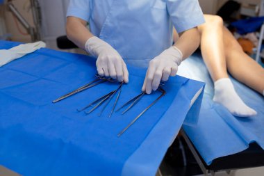 Doktor bacak damar ameliyatı için aletler düzenliyor