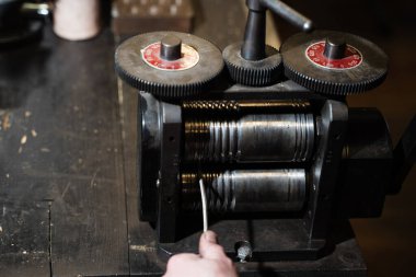 Kuyumcu, kablo veya ince şeritler üretmek için altın çekiyor.