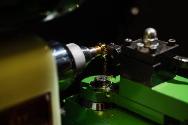 Mücevherci altın bir yüzüğü hassas bir makinede öğütüyor.