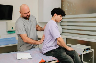 Ürolog, fiziksel muayene sırasında böbrek hassasiyetini ölçmek için böbrek muayenesi yapıyor.