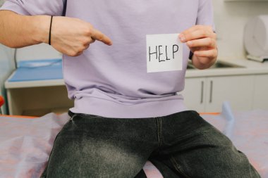 Genç adam idrar ağrısı ya da nephrolithiasis için kanada tutunma işareti gösteriyor.