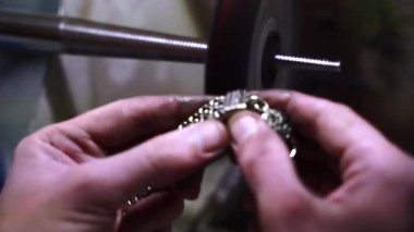 Zanaatkar, bileklik parlatmak için cilalama makinesi kullanıyor. 4K video, pürüzsüz bitiş için takı bilekliği takıyor..