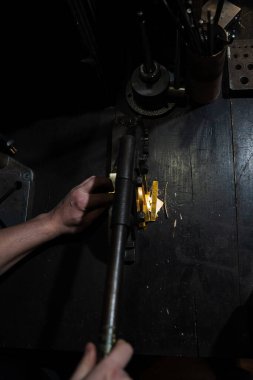 Kuyumcu özel bir kesiciyle altın çarşaf kesiyor.