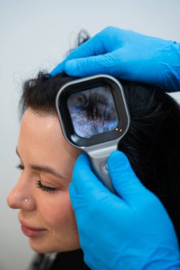 Kafa derisi durumunu değerlendirmek için aydınlatılmış büyüteçle üçgenbilim incelemesi