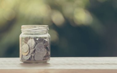 Yatırım kavramı için para biriktir. Arka plandaki cam kavanoza para koy.