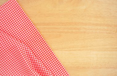 Ahşap masada kırmızı kontrol edilmiş kumaş.