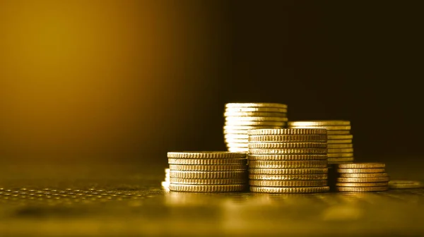 stack of coins and stacks of gold coin on black background