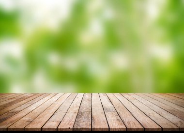 Ürün gösterimi için soyut doğal yeşil bulanık bokeh arkaplanı olan tahta kalas