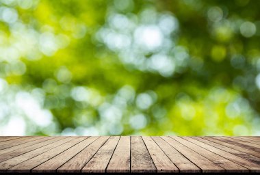 Ürün gösterimi için soyut doğal yeşil bulanık bokeh arkaplanı olan tahta kalas