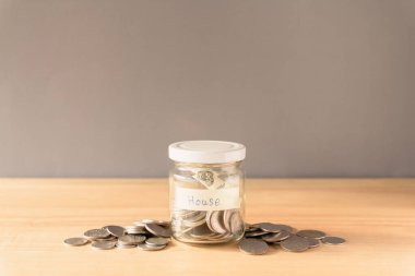 Para kavanozda, bozuk paralar da tahta zeminde.