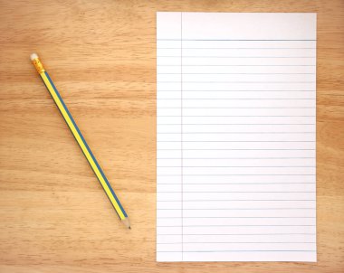 Ahşap zemin üzerinde kalem ve kalem olan boş bir not defteri