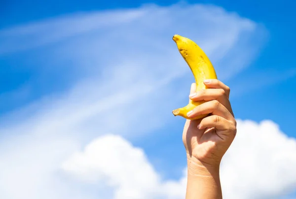 Ręka Kobiety Trzymającej Banany Tle Błękitnego Nieba — Zdjęcie stockowe