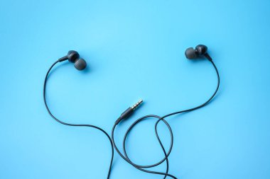 Mavi arkaplandaki kulaklıkların üst görünümü
