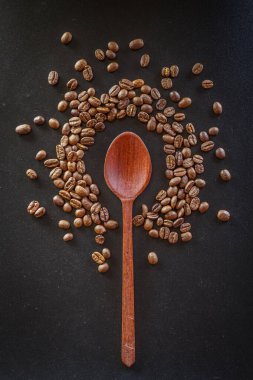 Siyah arka planda kaşık kahve çekirdekleri